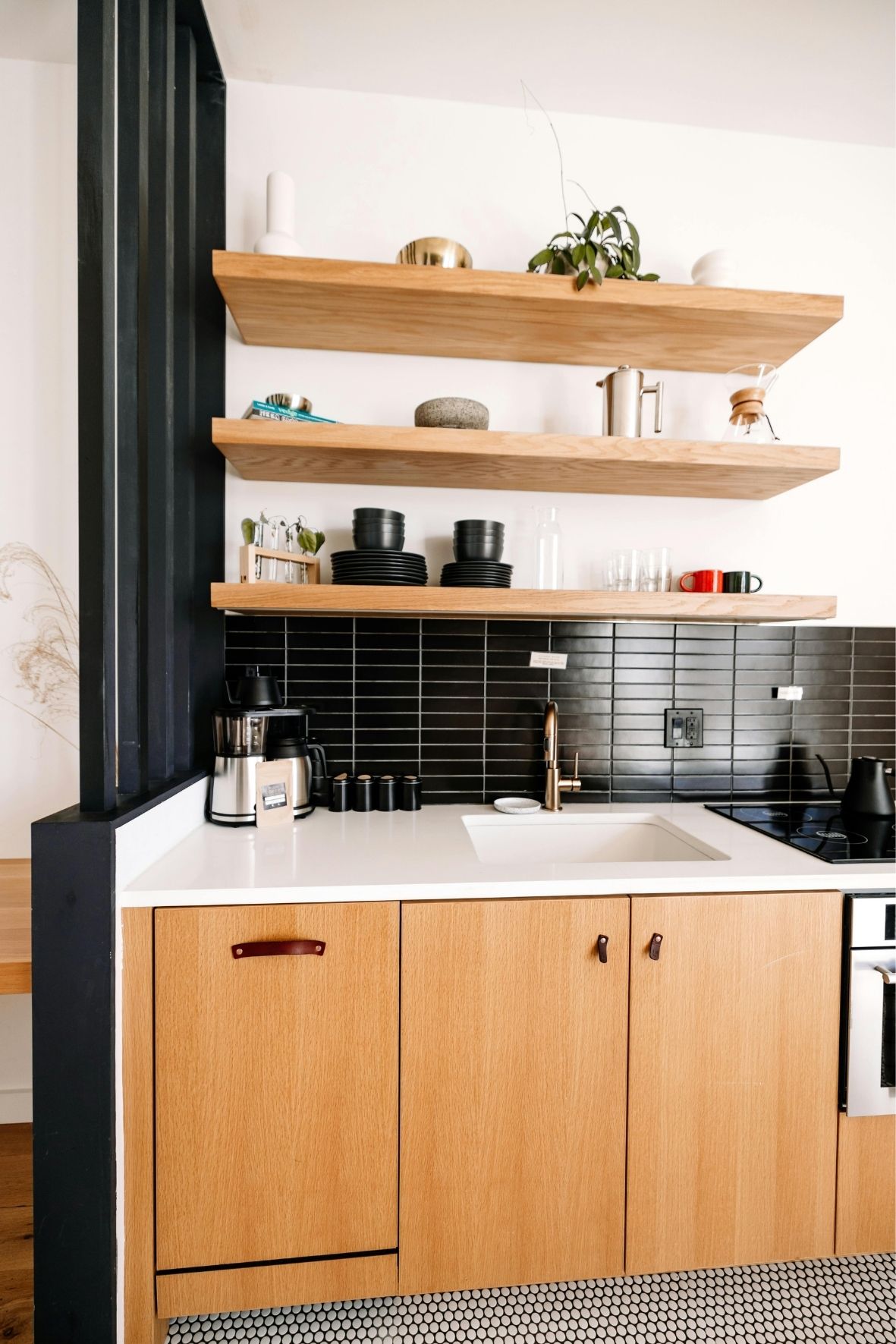 Cuisine fermée avec armoires foncées, crédence décorative et coin repas intégré dans un logement résidentiel  à Dolbeau-Mistassini